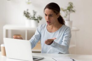 donna nervosa seduta davanti al computer